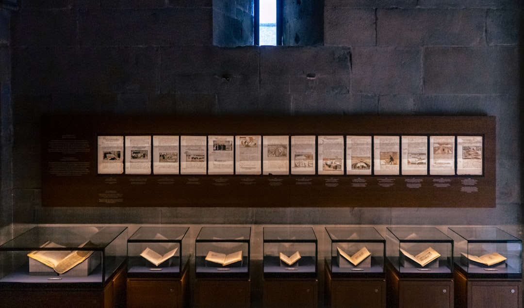 A row of books sitting on top of a wooden shelf
