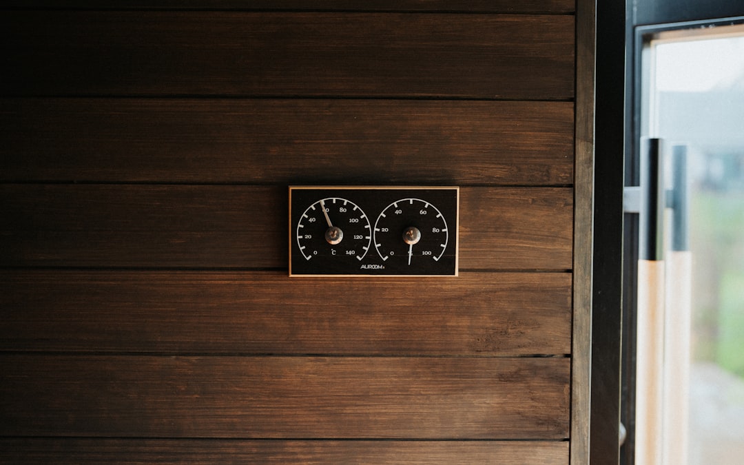 Two gauges mounted on a wooden wall.